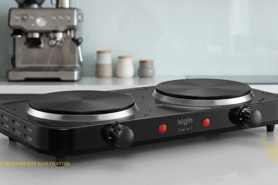 Uma fotografia de produto nítida e em close-up, no tamanho 1250x650 pixels, de um fogão elétrico de bancada da marca 'elgin' chamado "Cook for 2", posicionado sobre uma bancada de quartzo cinza claro em uma cozinha moderna de alto padrão. O aparelho tem um corpo preto lustroso e dois discos de aquecimento distintos. O disco esquerdo tem uma borda prateada lisa e uma superfície de cozimento texturizada com círculos concêntricos mais grossos. O disco direito é semelhante, mas com uma textura de círculos concêntricos mais finos. No painel frontal, centralizado entre as duas bocas, está o logotipo vermelho 'elgin' e, abaixo dele, o texto em preto "Cook for 2". À esquerda e à direita do texto, há dois botões de controle de temperatura pretos e nítidos, cada um com números de "0" a "5" impressos neles. Duas luzes indicadoras vermelhas pequenas estão acesas acima dos botões. O aparelho está apoiado sobre seus pés de borracha pretos integrados. O fundo está desfocado (bokeh), revelando formas indistintas de utensílios de cozinha modernos de aço escovado e cerâmica. A iluminação é de estúdio, suave e uniforme, sem sombras agressivas, garantindo a legibilidade clara de todo o texto e marca.